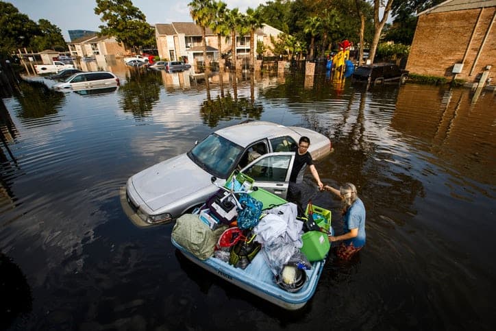 Flooding natural disaster. Woman trying to save her things. 