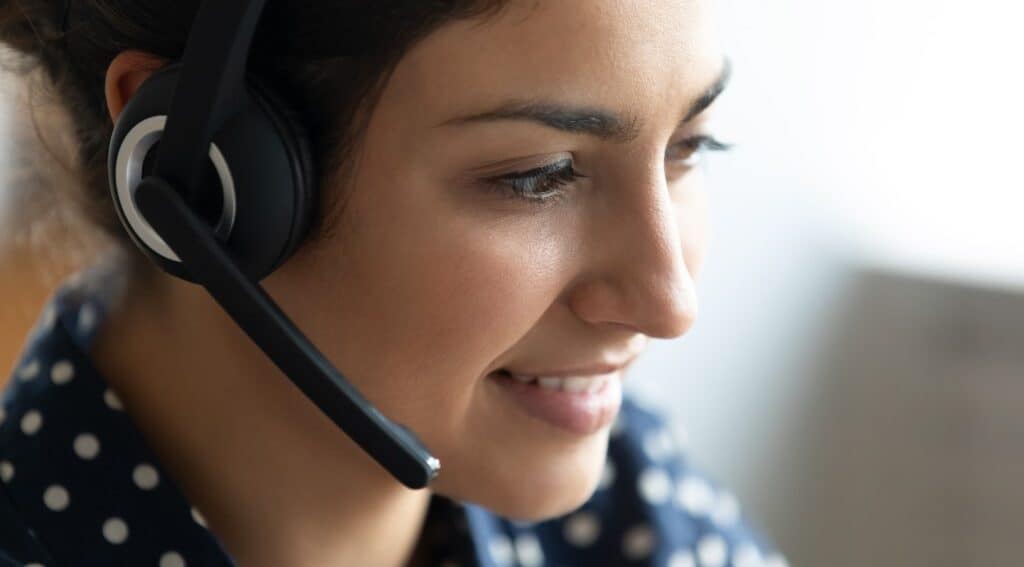 Virtual receptionist smiling while taking a call.